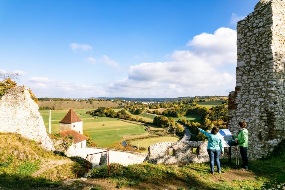 Zwei Personen blicken von einer Burg aus ins Tal.